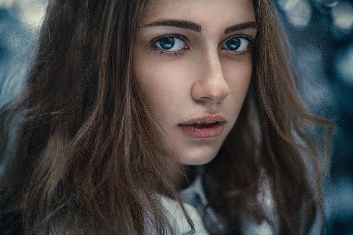 Close-up portrait of a young woman with blue eyes