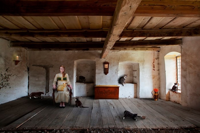 Woman with cats in an old wooden room
