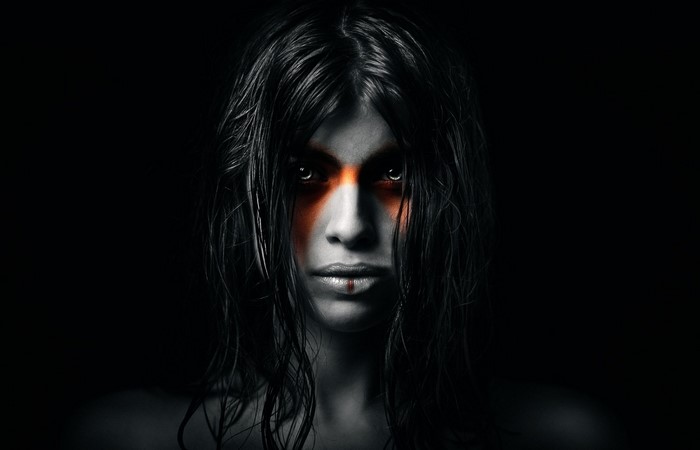Woman with orange face paint and black hair