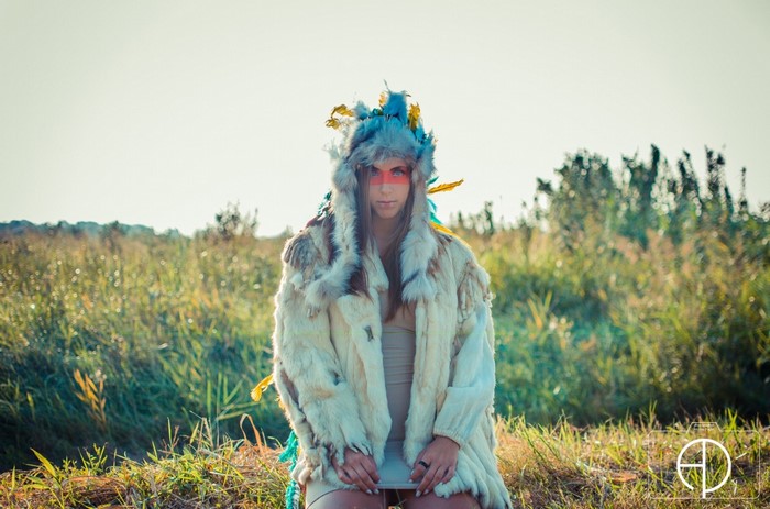 Woman in fur coat and headdress with face paint