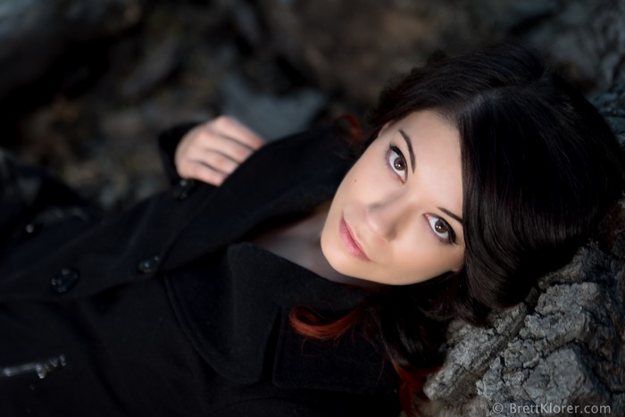 Woman with black hair and brown eyes wearing a black coat