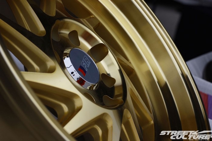 Close-up of a gold F1R wheel with a logo