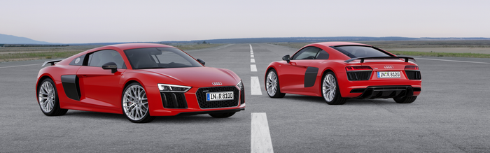 Two red Audi R8 sports cars on a road