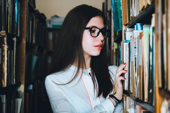 Young woman with glasses in a library