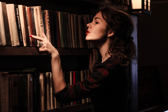 Woman in library reaching for books