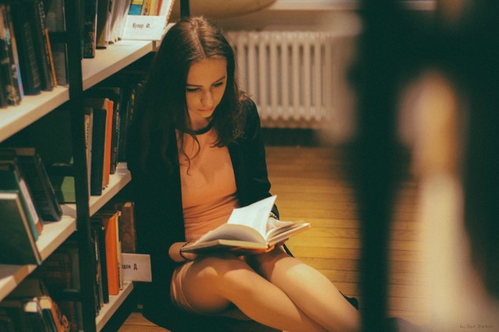 Woman reading a book in a library