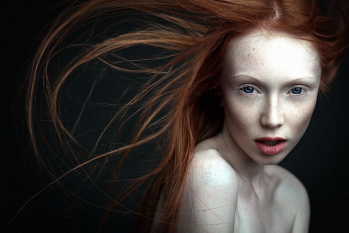 Portrait of a redhead woman with freckles and blue eyes