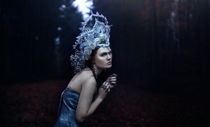 Woman with elaborate headdress in dark forest