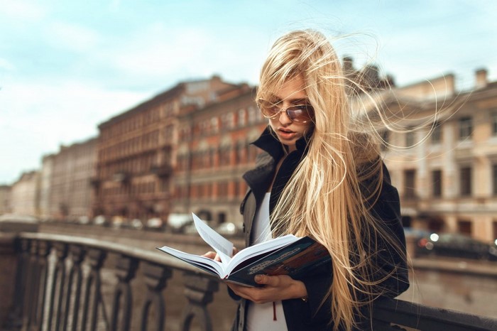 Woman with long blonde hair reading a book