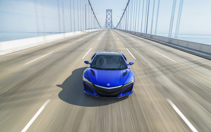 Blue Acura NSX driving on a bridge