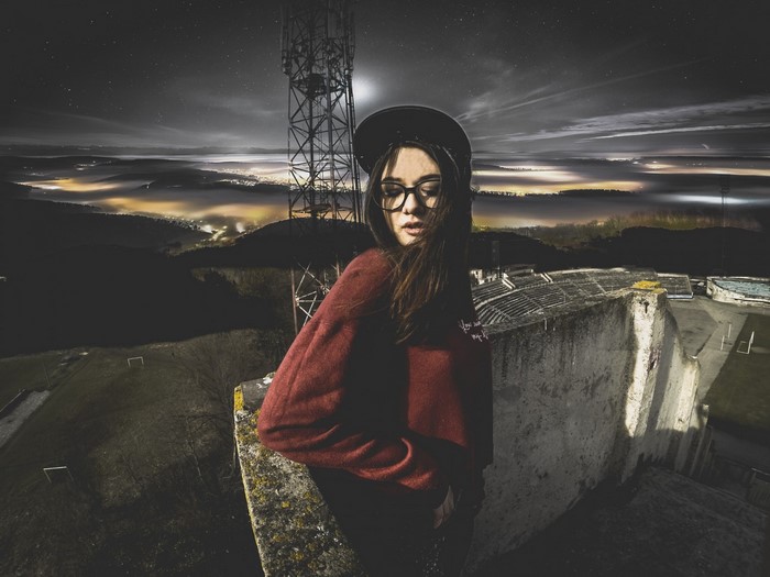 Woman wearing glasses and a hat at night