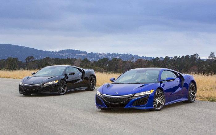 Two Acura NSX sports cars on a road