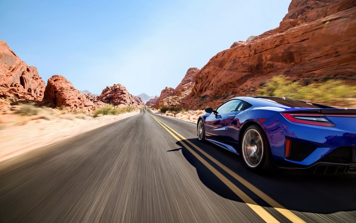 Blue Acura NSX driving on a desert road