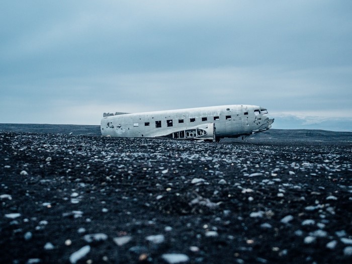 Wrecked Douglas DC-3 airplane on black sand beach