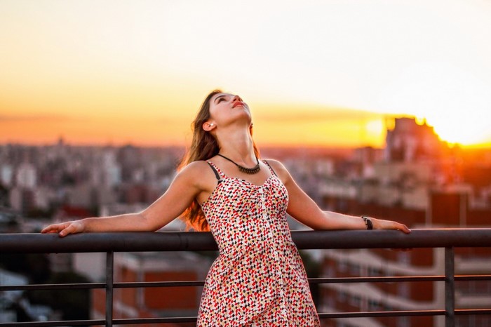 Woman in dress on balcony at sunset