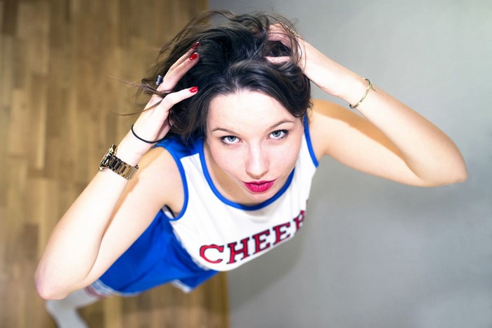 Woman in Cheerleader Outfit with Hands in Hair