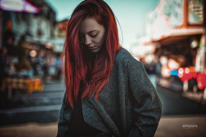 Redhead woman in a grey coat in a street