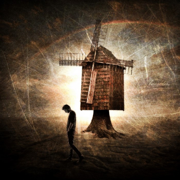 Man walking past a surreal windmill at sunset