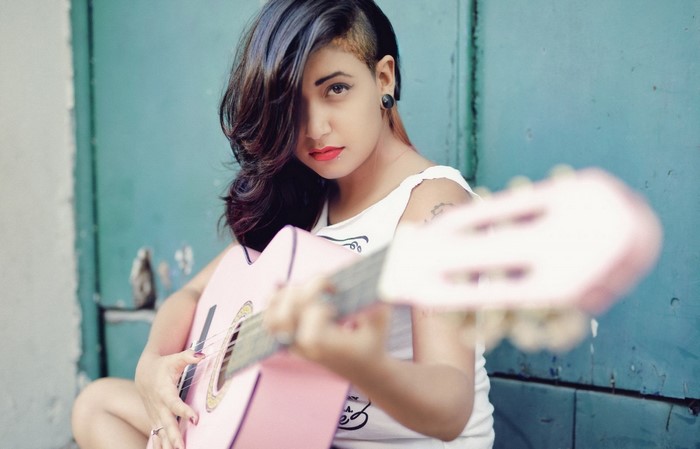 Woman playing a pink guitar