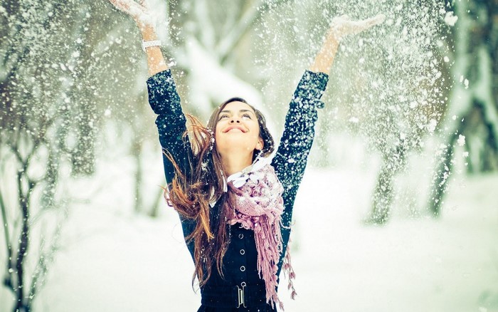 Woman throwing snow in winter