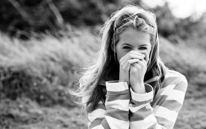 Monochrome portrait of a young woman covering her mouth