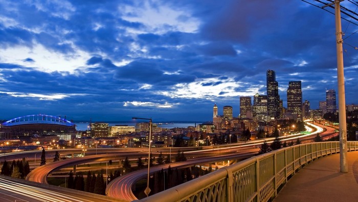 Seattle cityscape at dusk with stadium and highway