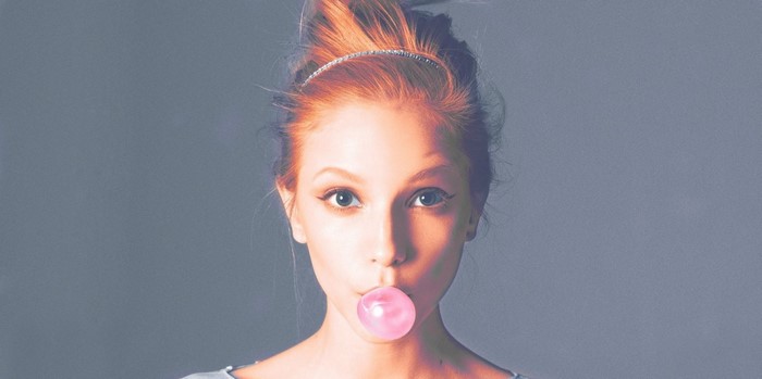 Woman with red hair blowing bubblegum