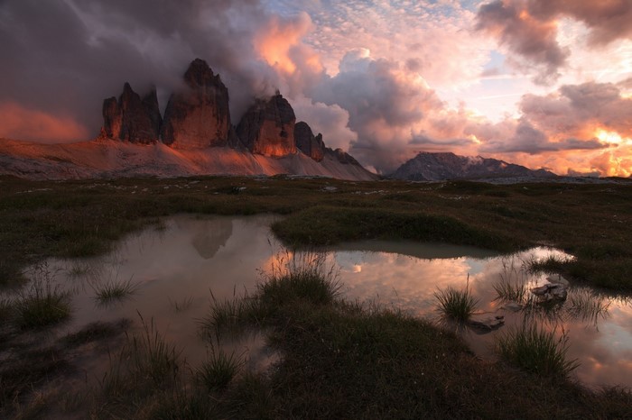 Tre Cime di Lavaredo mountains at sunset with reflection pond