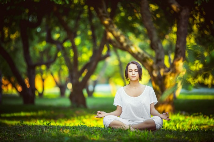 Woman meditating outdoors in a park