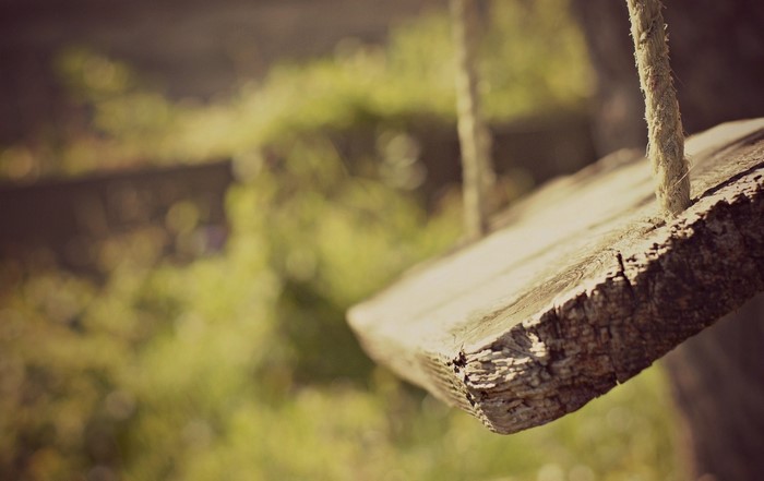 Close up of a wooden swing seat with rope