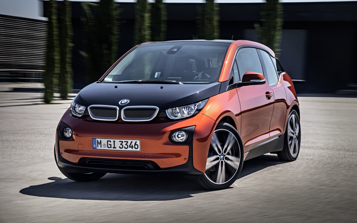 Orange BMW i3 electric car driving on pavement