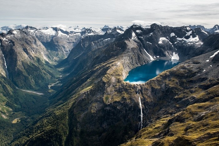 Snow-Capped Mountain Range with Waterfall and Glacier Lake