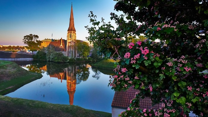 Church reflection in water with blooming trees in Copenhagen