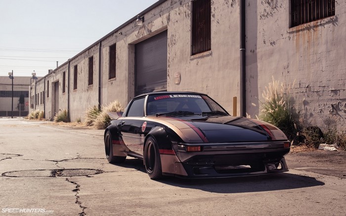 Modified Mazda RX-7 parked in an industrial alley