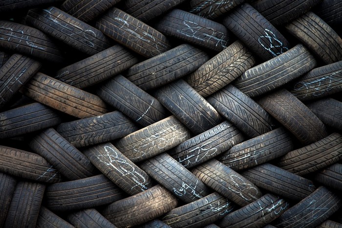 Pile of used car tires with white markings