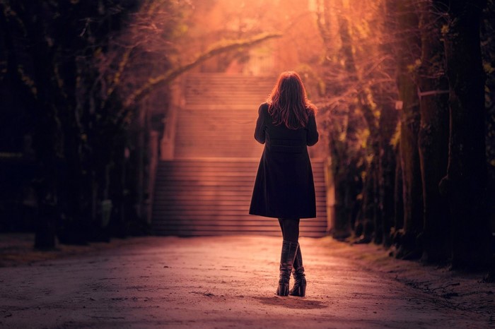 Woman walking up stairs at sunset