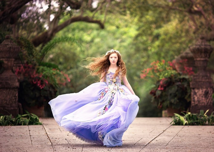 Young woman in a flowing purple dress with flowers
