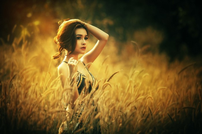 Woman Standing in Golden Sunlit Field