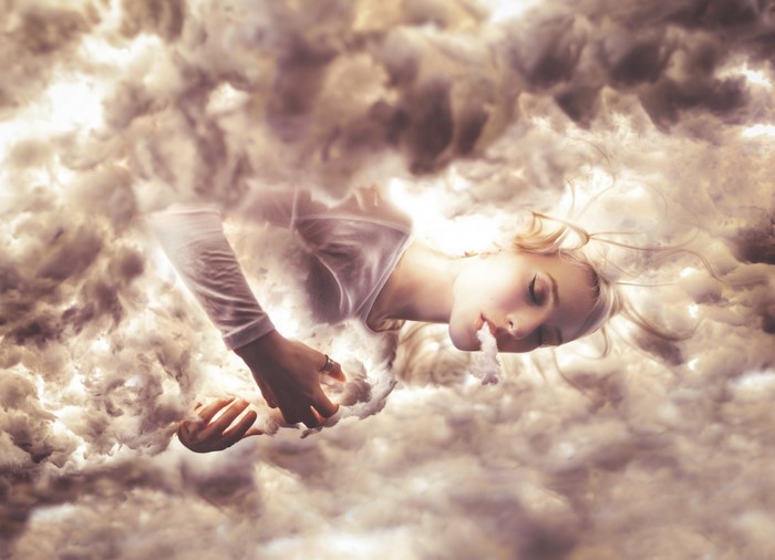 Woman floating in clouds with sunlight