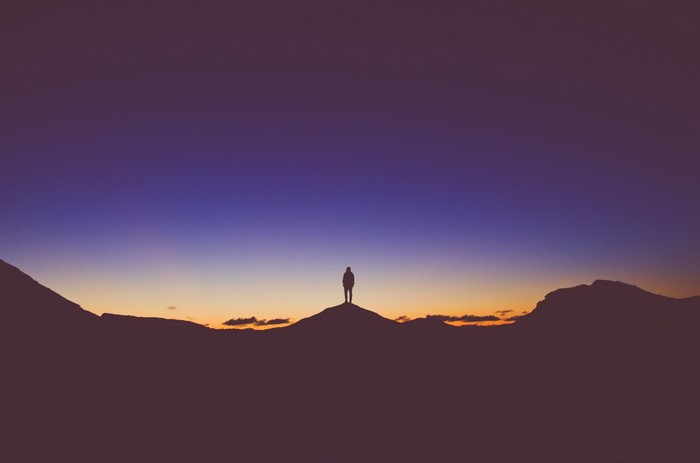 Silhouette of a person on a mountain at sunset