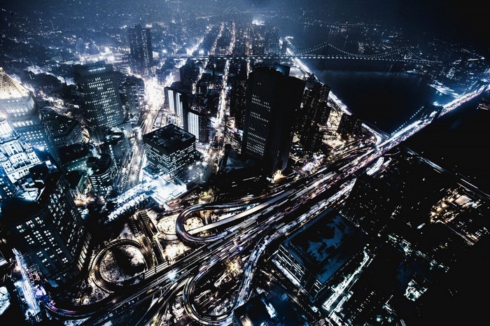 Aerial view of a city at night with highways and skyscrapers