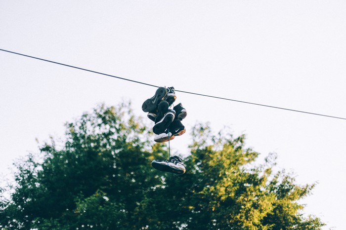 Shoes hanging on a power line over trees