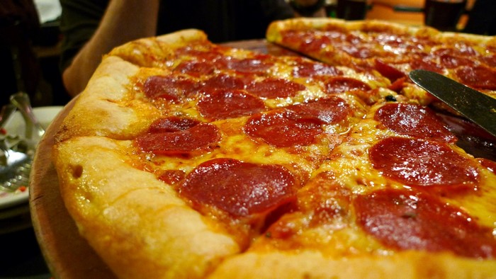 Close-up of a pepperoni pizza with a knife