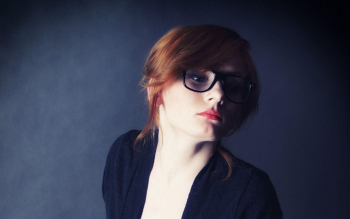 Redhead woman with glasses wearing black cardigan