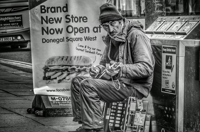 Man playing guitar in front of a store advertisement