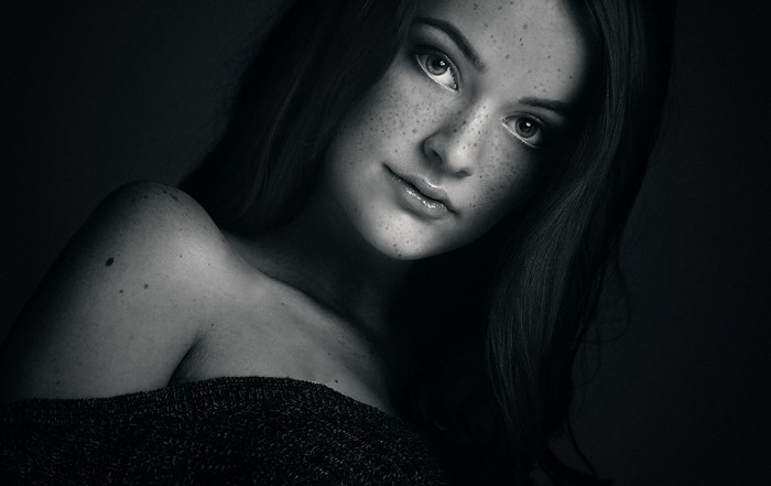 Monochrome portrait of a young woman with freckles
