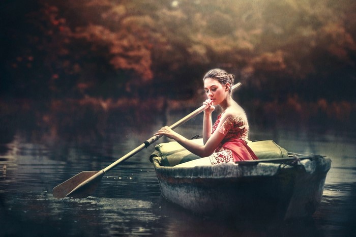 Woman in a boat rowing on water