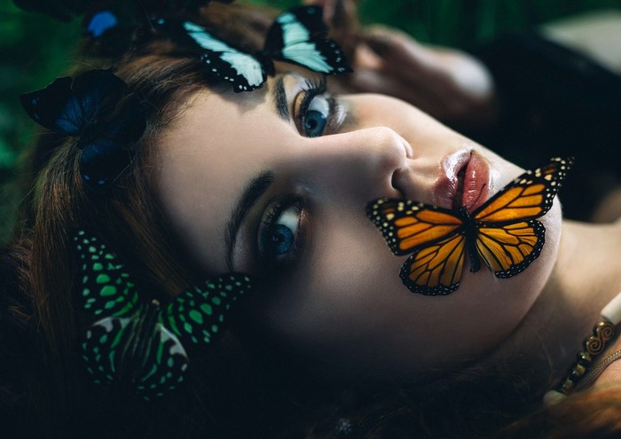 Woman with blue eyes and butterflies on face