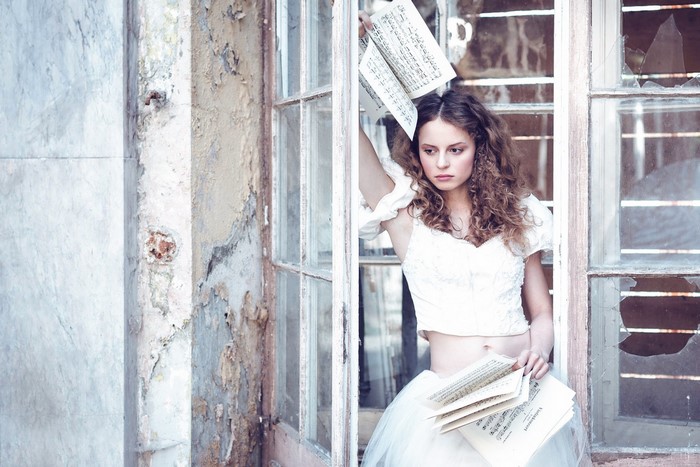 Woman in white dress holding musical notes