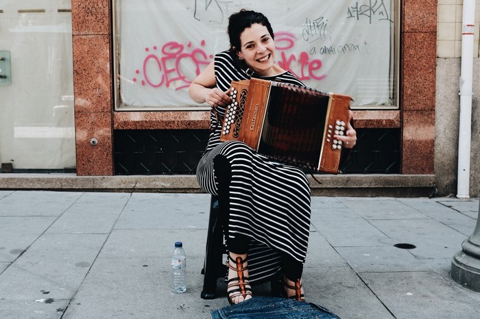 Woman playing accordion on a city street